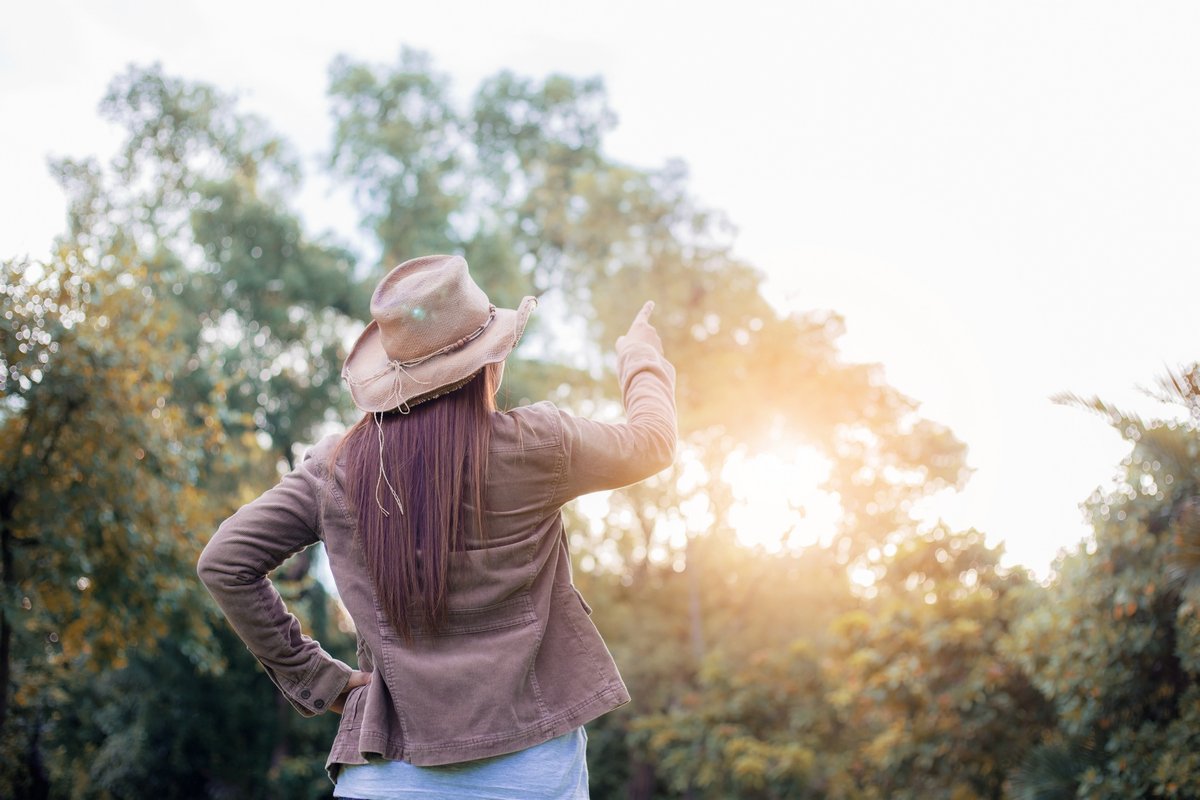 Woman in forest with the sunlight at sky in summer.